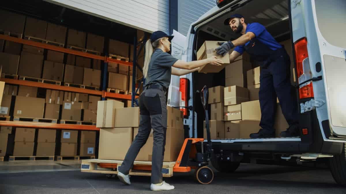 2 personnes portent des cartons à la main ce qui entraine des risques ergonomique et de la pénibilité