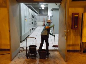 Une opératrice nettoie un local électrique. Elle doit être habilitée B0 ou H0 ou H0V d'après la norme NF C18-510