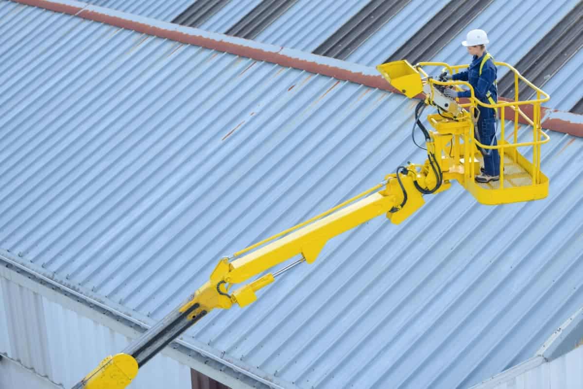 Une opératrice conduit une nacelle, PEMP 3B avec son CACES et son autorisation de conduite